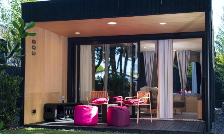 Gemütliche moderne Veranda mit bunten Stühlen und entspannter Atmosphäre.