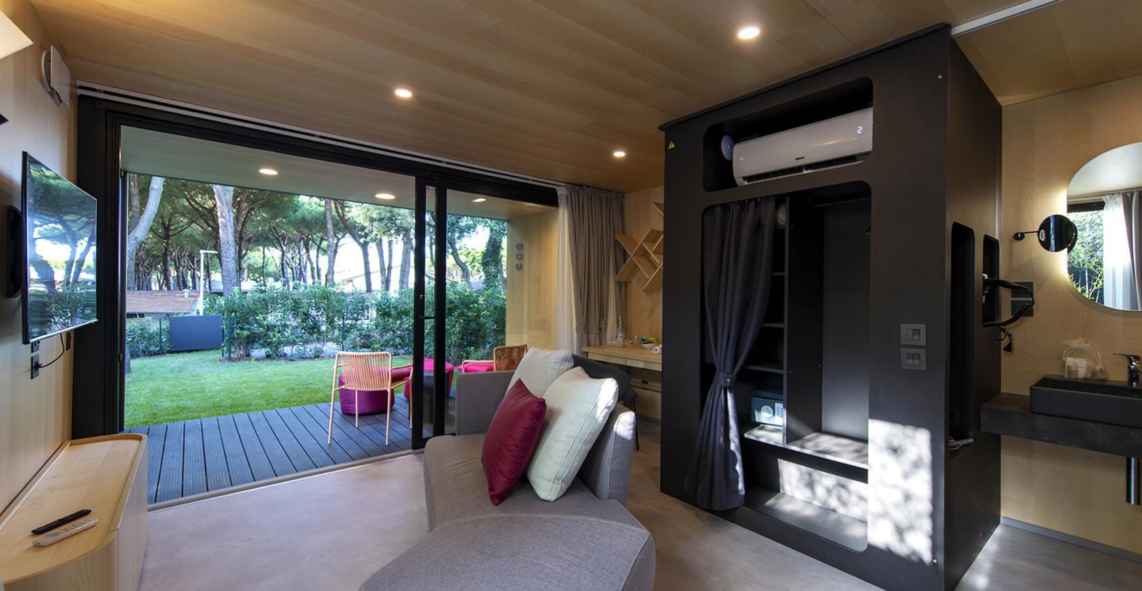 Interno moderno e luminoso con vista su un giardino verde, atmosfera rilassante e accogliente.