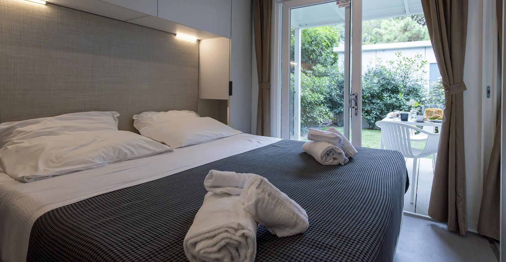Camera accogliente con letto matrimoniale, vista giardino, atmosfera rilassante e intima.