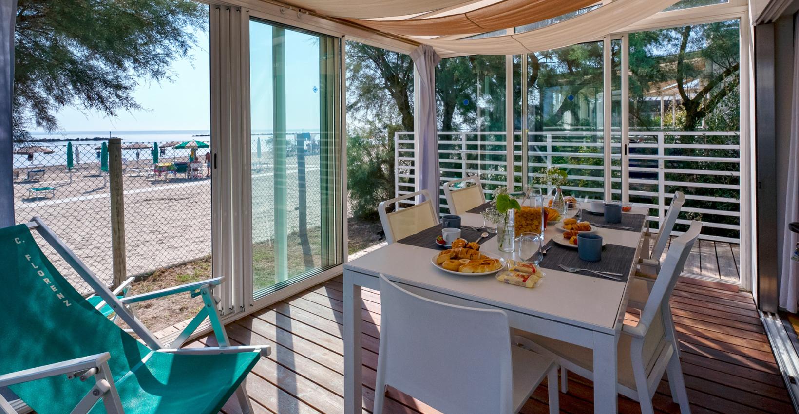 Terrazza soleggiata vista mare, colazione invitante, atmosfera rilassante e vacanziera.