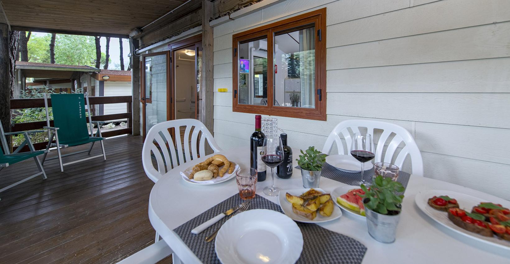 Terrazza accogliente con tavola imbandita e calde luci, perfetta per una cena all'aperto.