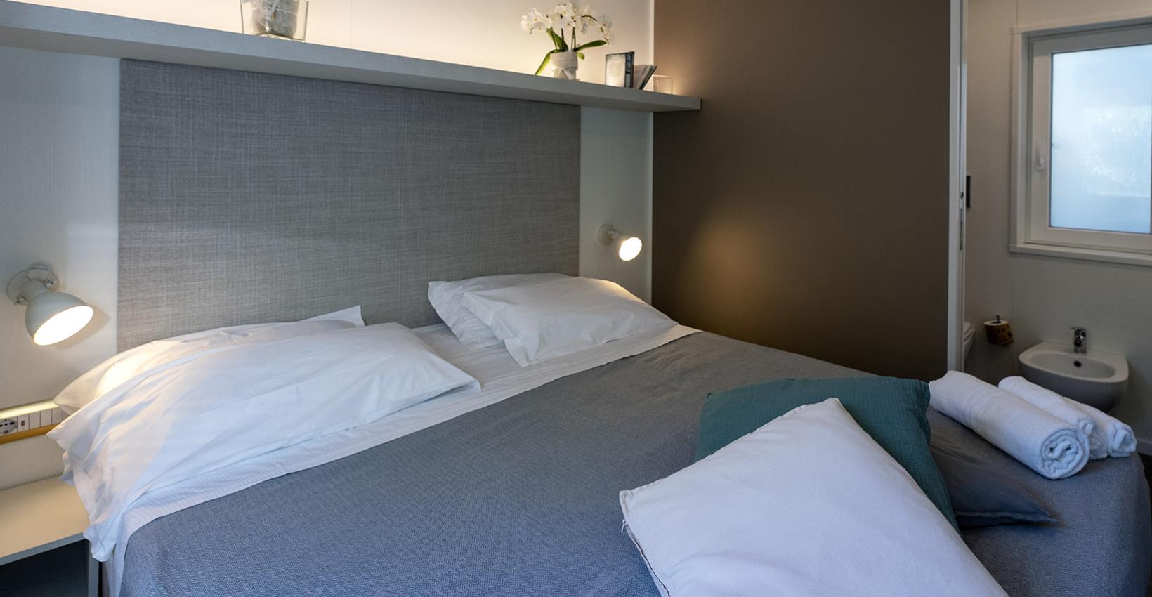 Camera moderna e accogliente, con letto matrimoniale, luci soffuse e decorazioni floreali.
