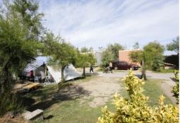 Campeggio tranquillo con tenda, alberi e cielo sereno, atmosfera di relax e avventura.