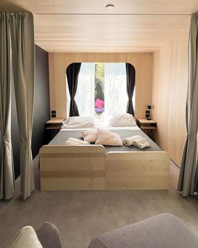 Camera accogliente con letto matrimoniale, tende eleganti e luce naturale che illumina dolcemente.