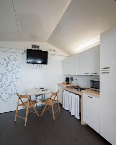 Cucina moderna e minimalista, con tavolo e sedie pieghevoli, trasmette semplicità e funzionalità.