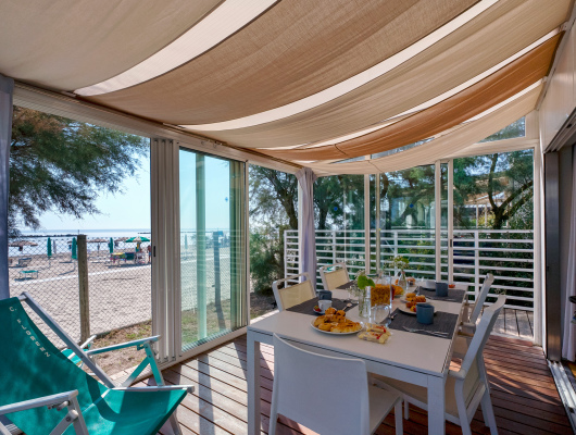 Terrazza soleggiata vista mare, colazione invitante, atmosfera rilassante e vacanziera.
