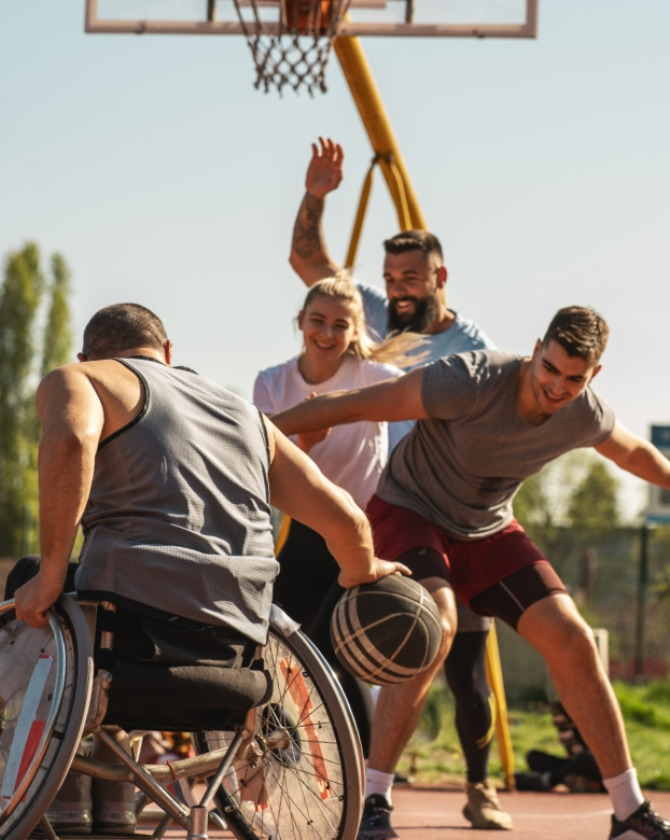 Gioco di basket inclusivo all'aperto, sorrisi e impegno sotto il sole.
