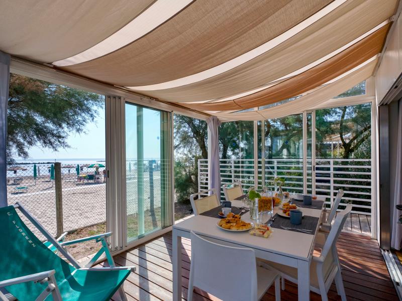 Terrazza soleggiata vista mare, colazione invitante, atmosfera rilassante e vacanziera.
